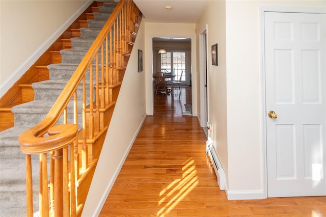 corridor with hardwood / wood-style flooring and a baseboard radiator