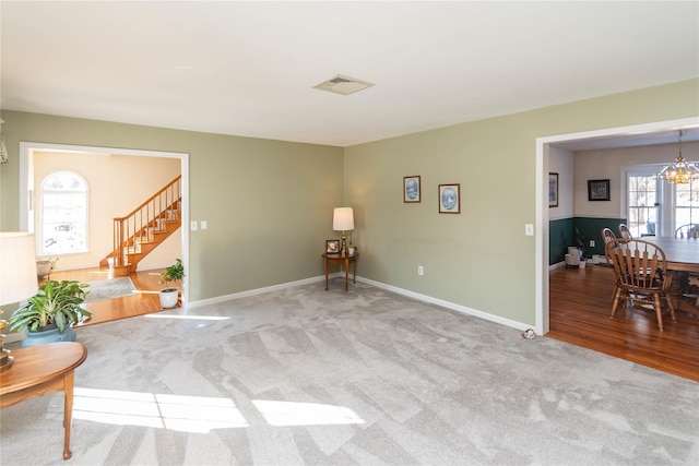 living area featuring an inviting chandelier and light colored carpet