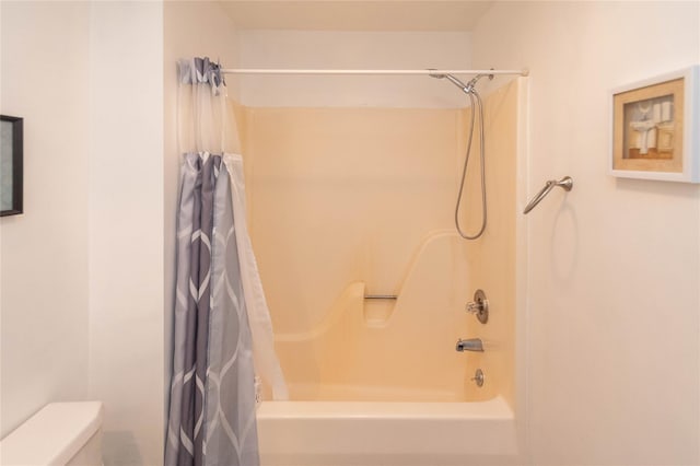 bathroom with shower / tub combo with curtain and toilet