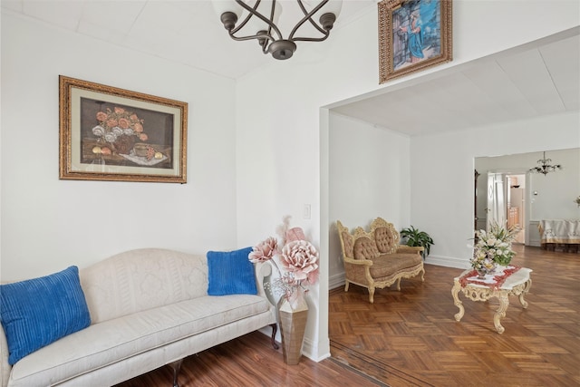 living area with a notable chandelier and dark parquet flooring