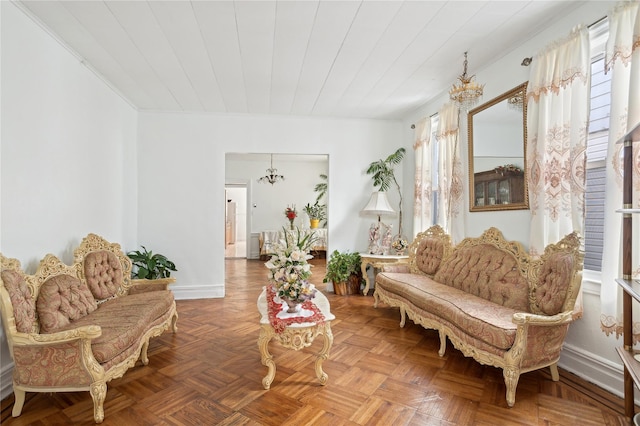 sitting room featuring an inviting chandelier, parquet flooring, and ornamental molding