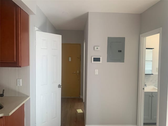 corridor featuring wood-type flooring and electric panel