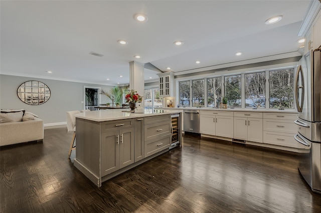 kitchen with stainless steel appliances, dark hardwood / wood-style floors, white cabinets, and a kitchen island