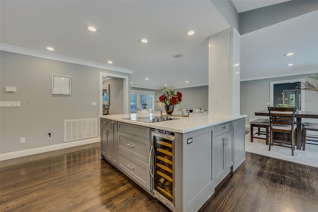 kitchen with wine cooler, gray cabinetry, crown molding, dark hardwood / wood-style flooring, and black electric stovetop