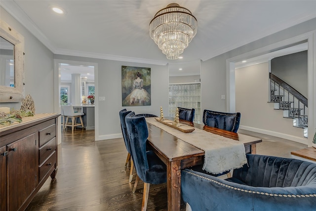 dining room featuring a tiled fireplace, crown molding, dark hardwood / wood-style floors, and a chandelier