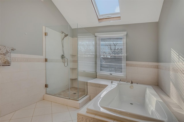 bathroom with tile patterned flooring, shower with separate bathtub, and vaulted ceiling with skylight