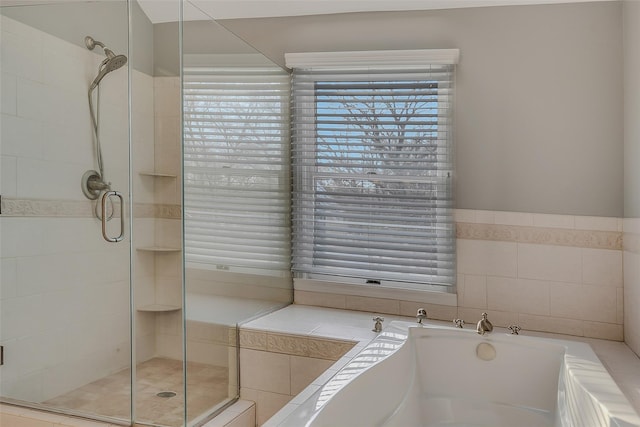 bathroom featuring plus walk in shower and tile walls