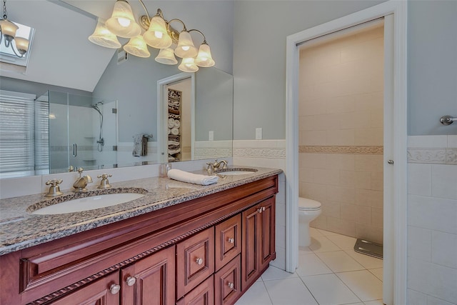 bathroom featuring tile walls, vanity, tile patterned floors, toilet, and walk in shower