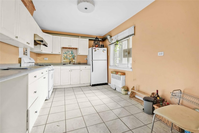 kitchen featuring light tile patterned floors, white appliances, sink, white cabinetry, and radiator heating unit