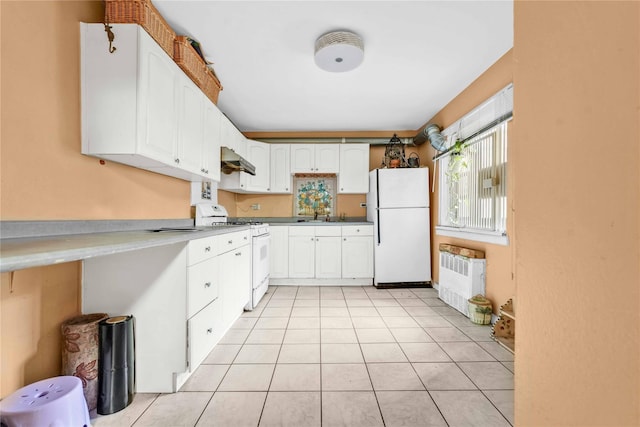 kitchen with white cabinetry, radiator, light tile patterned floors, and white appliances