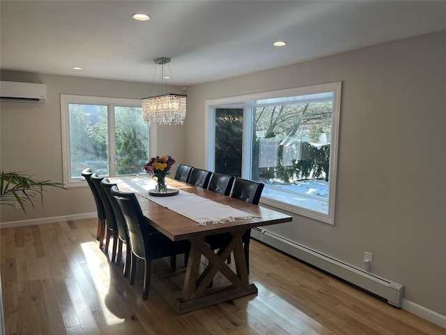 dining room featuring a wall unit AC, light hardwood / wood-style floors, and baseboard heating