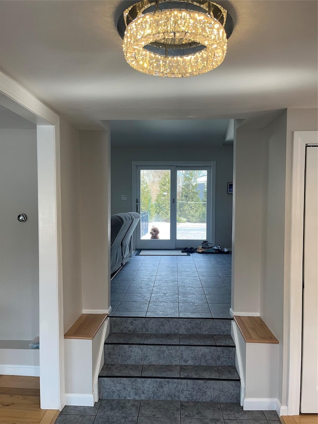 stairway featuring tile patterned floors and an inviting chandelier