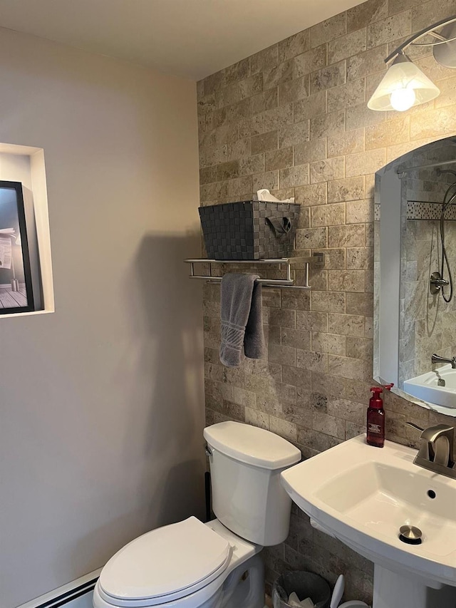 bathroom with a baseboard heating unit, sink, and toilet