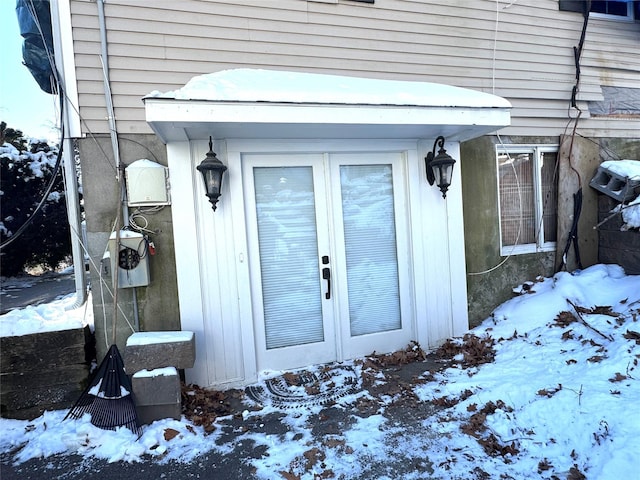 snow covered property entrance with french doors