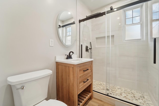 bathroom featuring vanity, toilet, an enclosed shower, and hardwood / wood-style floors