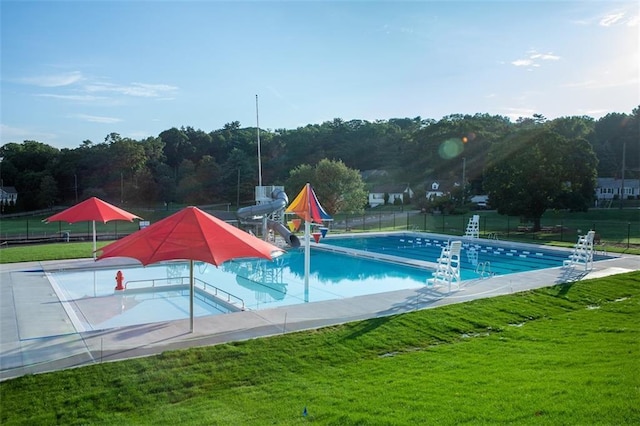 view of pool featuring a lawn