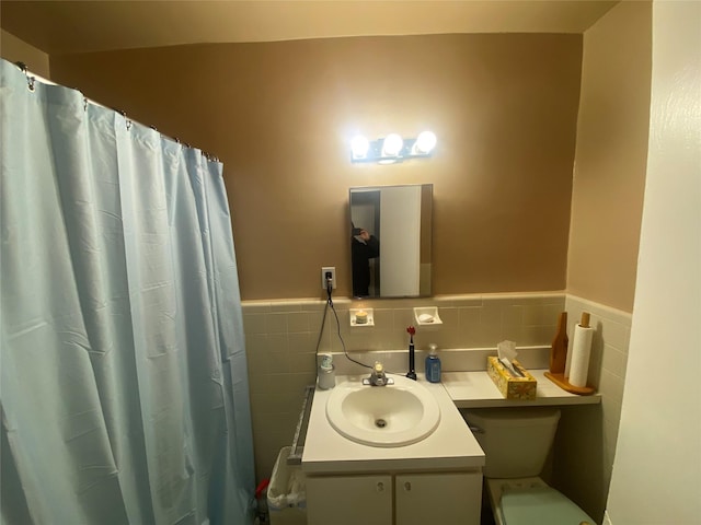 bathroom with a shower with curtain, vanity, tile walls, and toilet