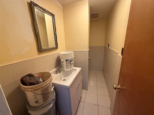 bathroom featuring tile patterned flooring, vanity, and tile walls