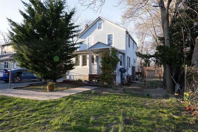 traditional home with a front lawn, a chimney, and stucco siding