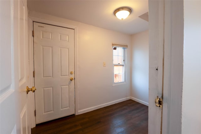 interior space featuring baseboards and dark wood-style flooring