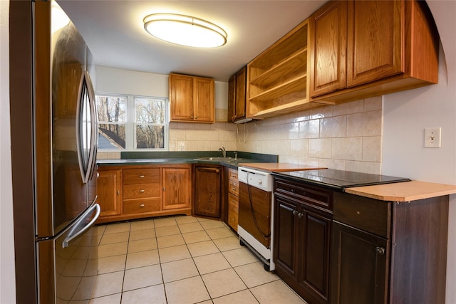kitchen featuring decorative backsplash, freestanding refrigerator, light tile patterned floors, and dishwashing machine