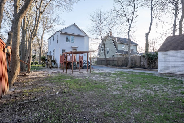 back of property with an outdoor structure, a storage unit, stairway, and fence