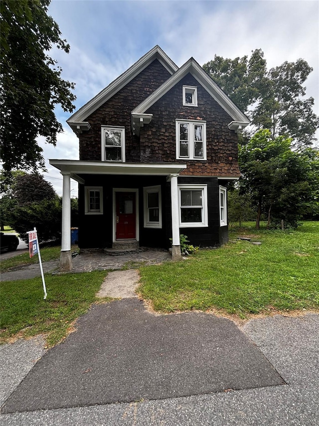 view of front of property with a porch and a front lawn