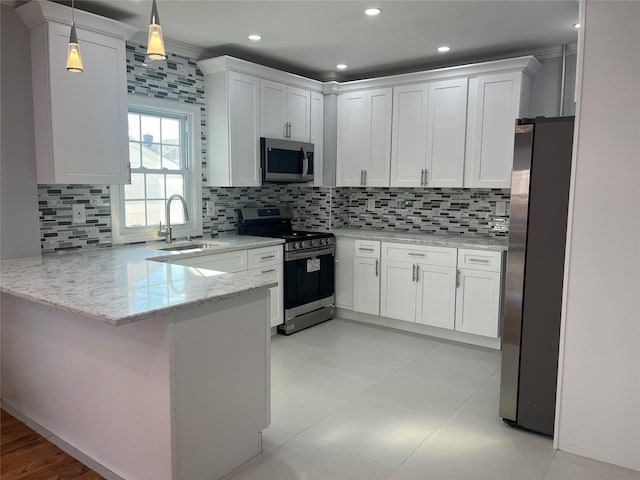 kitchen featuring appliances with stainless steel finishes, white cabinetry, sink, hanging light fixtures, and kitchen peninsula