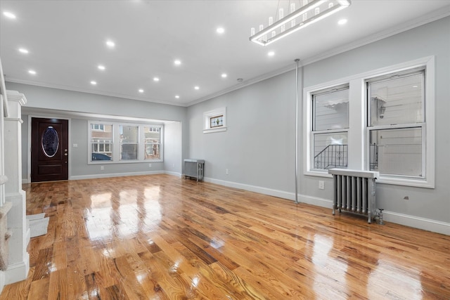 unfurnished living room with ornamental molding, radiator, and light hardwood / wood-style flooring