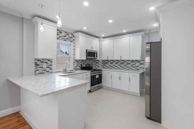 kitchen with white cabinetry, sink, stainless steel appliances, and kitchen peninsula