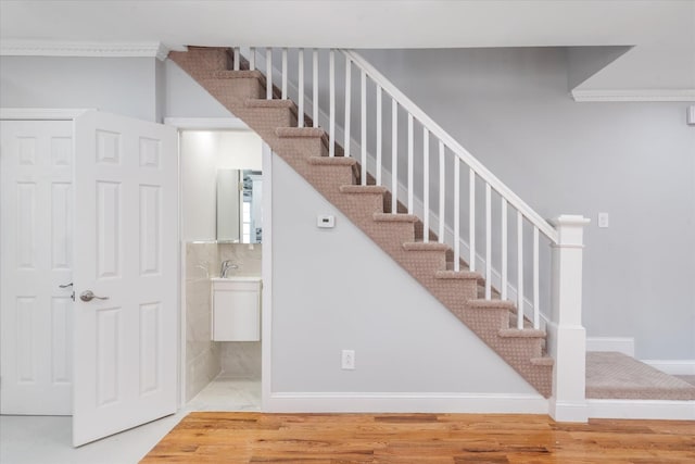 staircase featuring crown molding and hardwood / wood-style floors