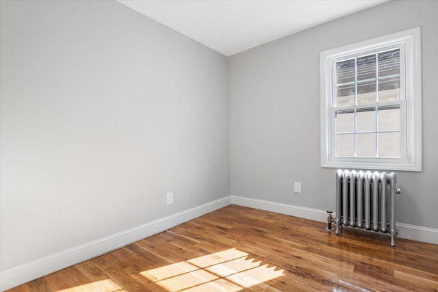 spare room featuring hardwood / wood-style flooring and radiator heating unit