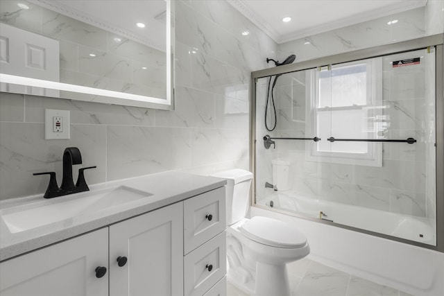 full bathroom with toilet, crown molding, shower / bath combination with glass door, tile walls, and vanity