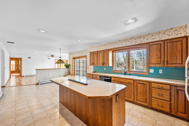 kitchen with black appliances, a sink, light countertops, and wallpapered walls