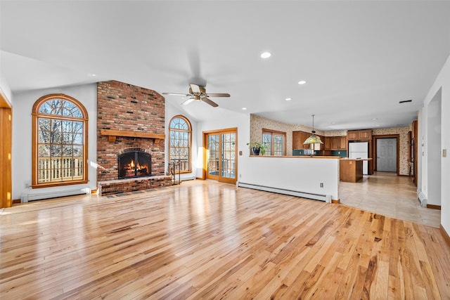 unfurnished living room featuring lofted ceiling, light wood finished floors, plenty of natural light, and baseboard heating