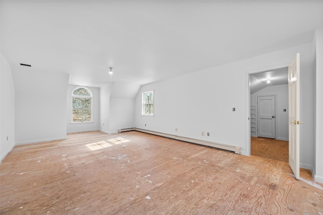 unfurnished living room with a baseboard heating unit and lofted ceiling