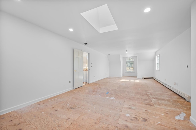 unfurnished living room with a skylight, baseboards, a baseboard heating unit, and recessed lighting