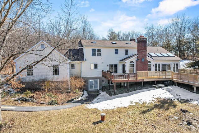 rear view of house featuring french doors, a chimney, and a wooden deck