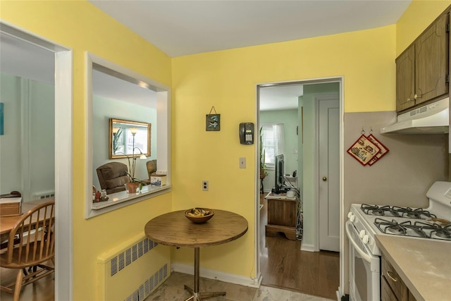 kitchen with radiator heating unit and white gas range oven