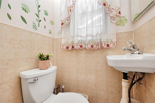 bathroom featuring tile walls and toilet