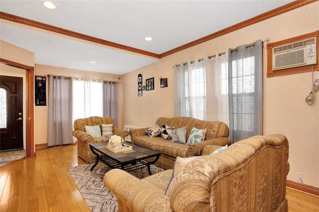 living room featuring ornamental molding, light hardwood / wood-style floors, and an AC wall unit