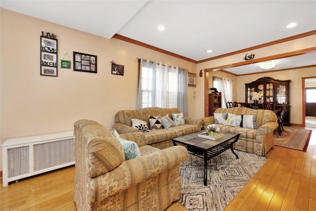 living room featuring crown molding, radiator heating unit, and light hardwood / wood-style flooring