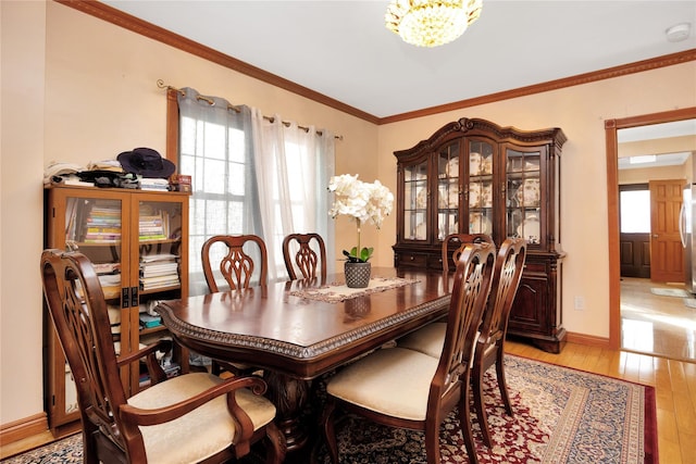 dining room featuring crown molding, a notable chandelier, and light wood-type flooring