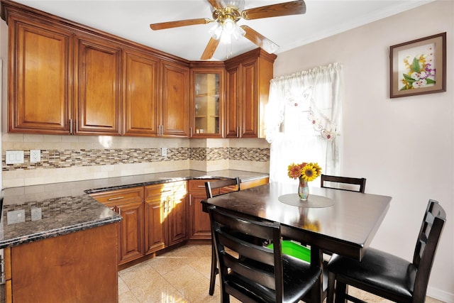 kitchen with dark stone countertops, ceiling fan, and decorative backsplash