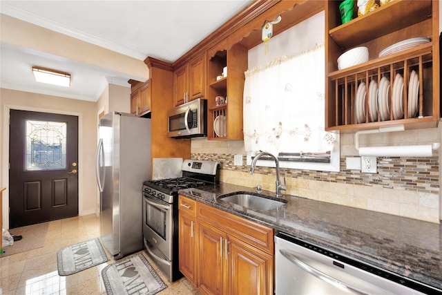 kitchen featuring sink, crown molding, appliances with stainless steel finishes, backsplash, and dark stone counters