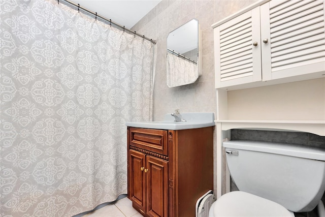 bathroom featuring tile patterned floors, toilet, tile walls, and vanity