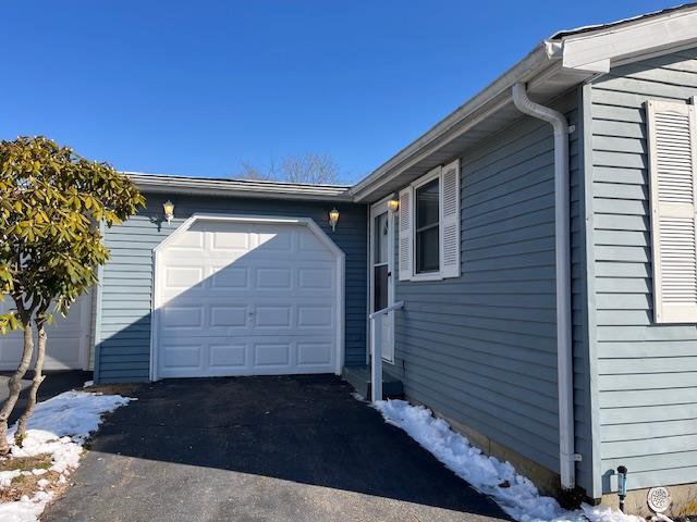 snow covered property with a garage