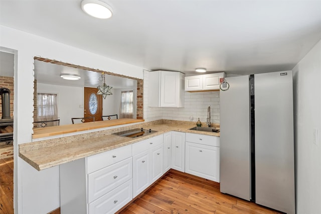 kitchen featuring sink, white cabinets, backsplash, and kitchen peninsula