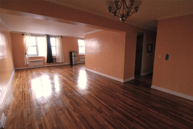 unfurnished living room featuring ornamental molding, radiator, dark hardwood / wood-style floors, and a notable chandelier