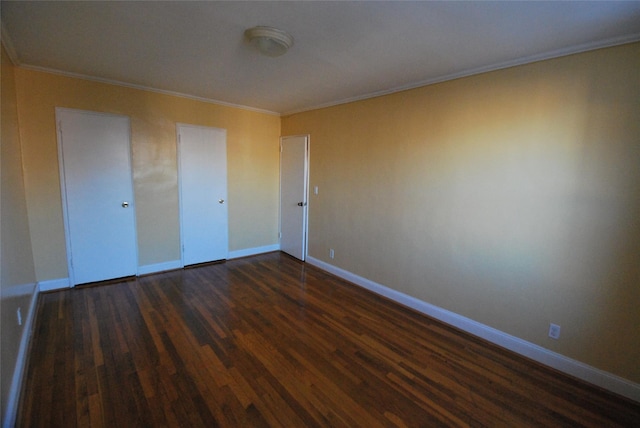 empty room with dark wood-type flooring and crown molding